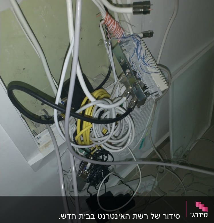 חוטי רשת מחוברים ללוח תקשורת בקיר